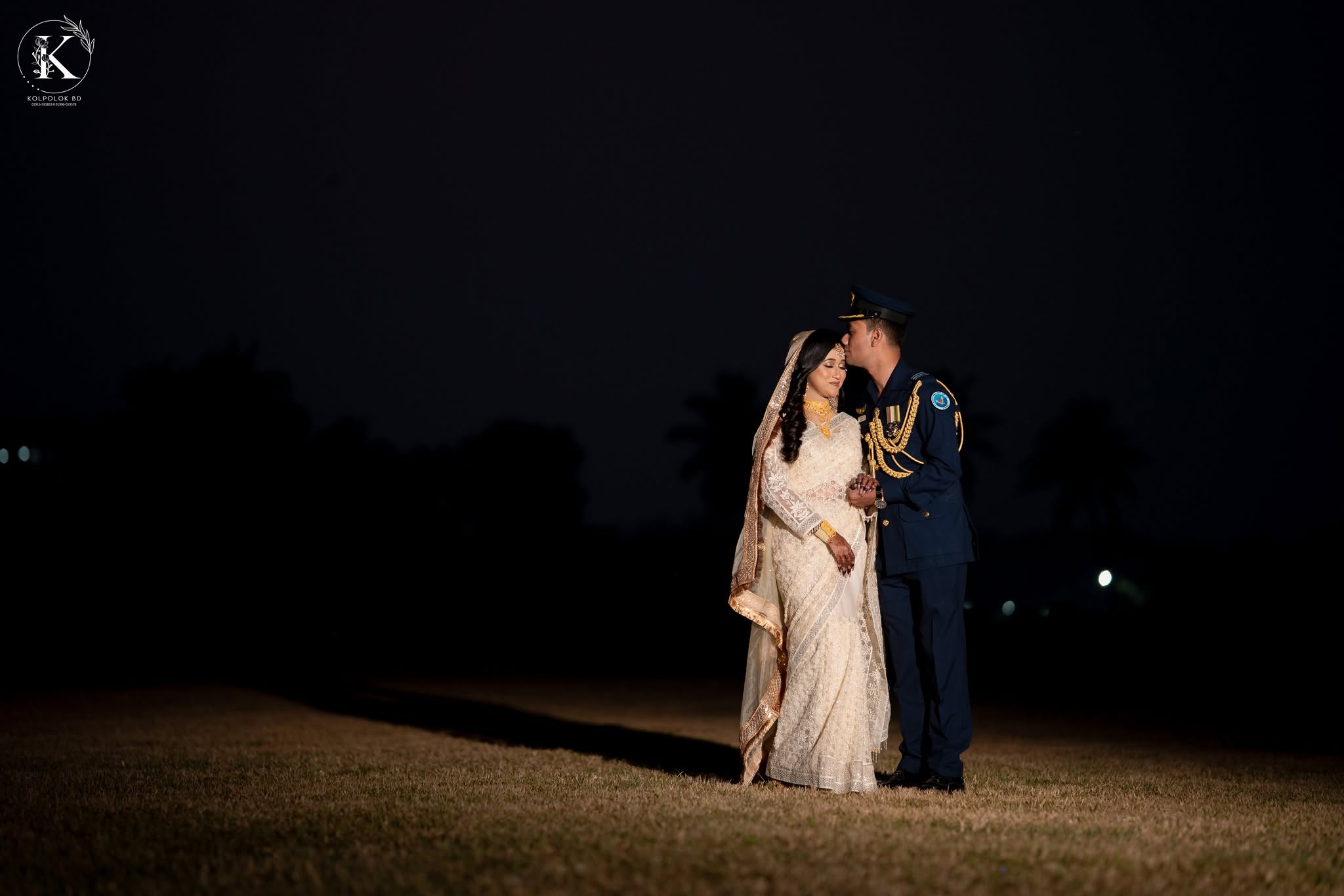 Air Force officer kissing his bride at night