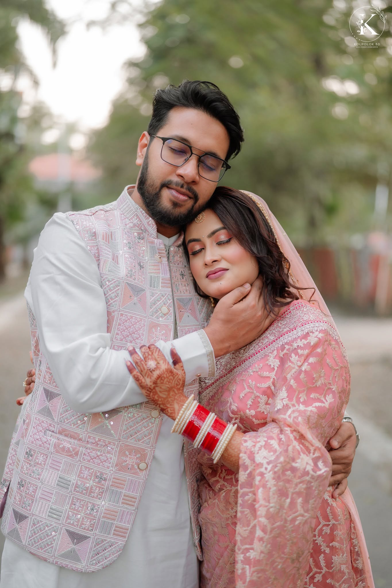 Couple embracing in soft pink traditional attire