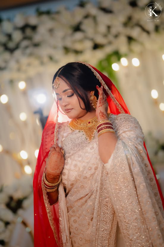 Bride adjusting her red veil